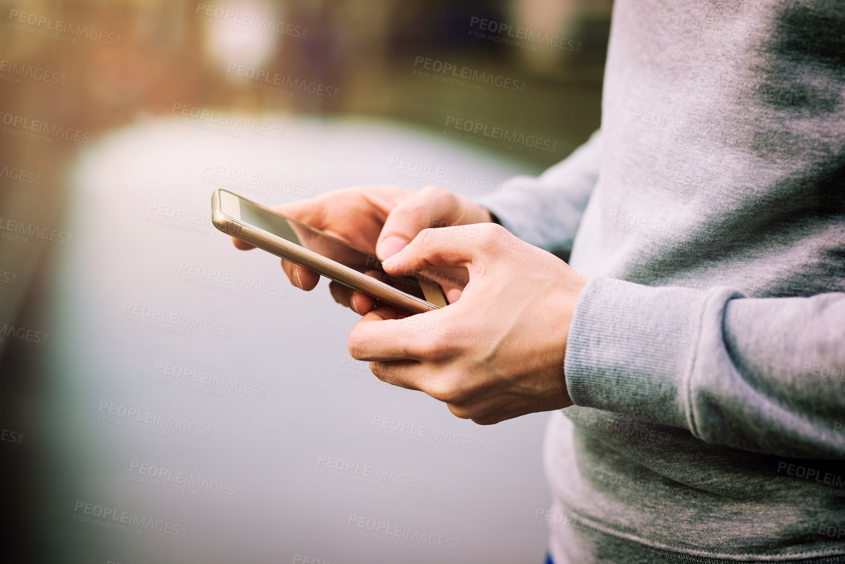 Buy stock photo Cropped shot of a man using his mobile phone outdoors