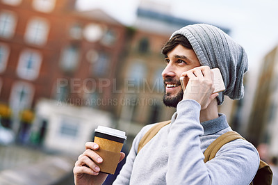 Buy stock photo Shot of a young man using his mobile phone while out in the city