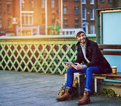 Buy stock photo Man, happy and waiting in city for travel, social media and communication with tablet on holiday. Male person, technology and bus stop in urban town for commute, tourism or web with break on vacation