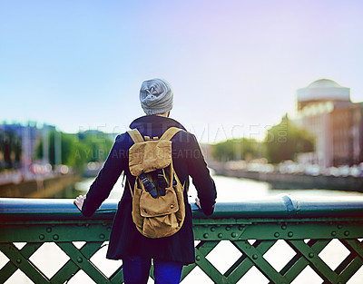 Buy stock photo Rearview shot of a young man looking at the city view from a bridge