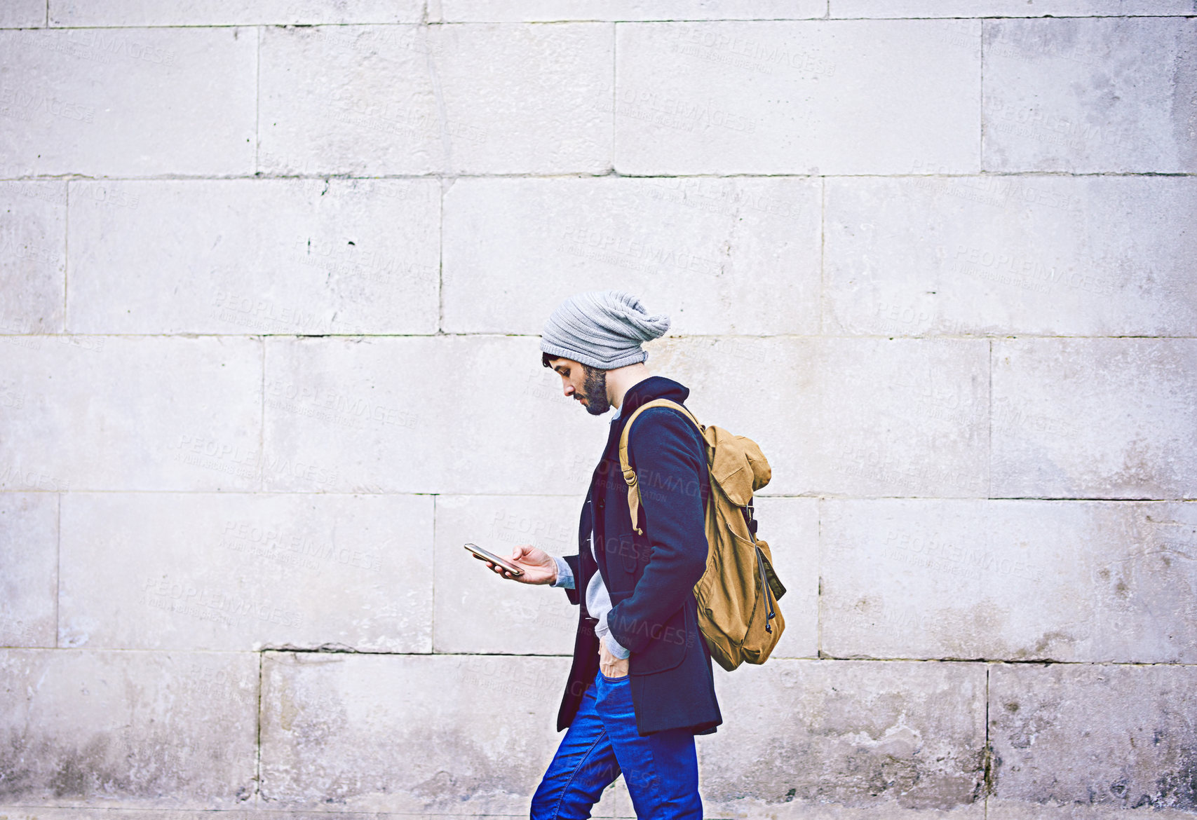 Buy stock photo Shot of a young man using his mobile phone while out in the city