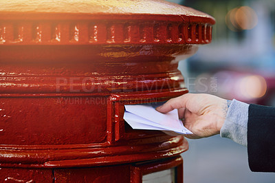 Buy stock photo Cropped shot of a man posting mail into a postbox in the city