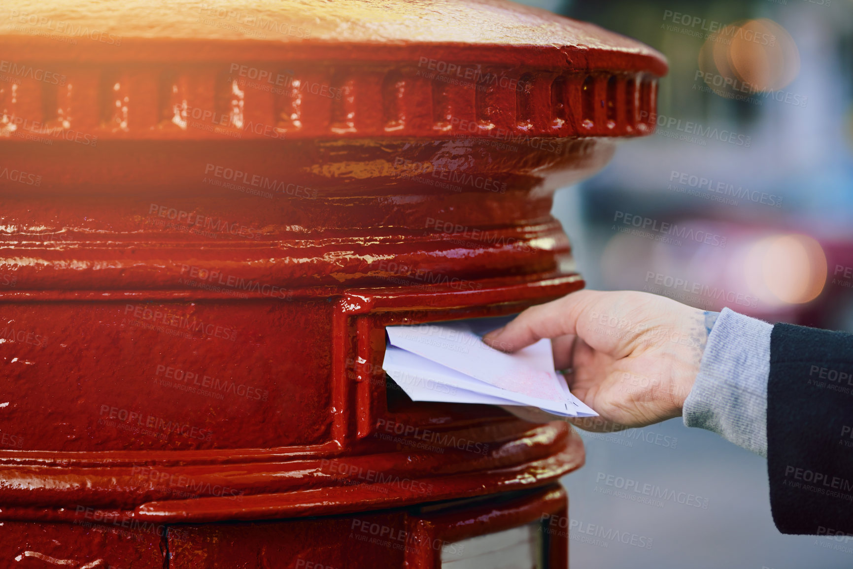 Buy stock photo Cropped shot of a man posting mail into a postbox in the city