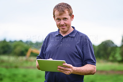 Buy stock photo Shot of a farmer using a digital tablet on his farm