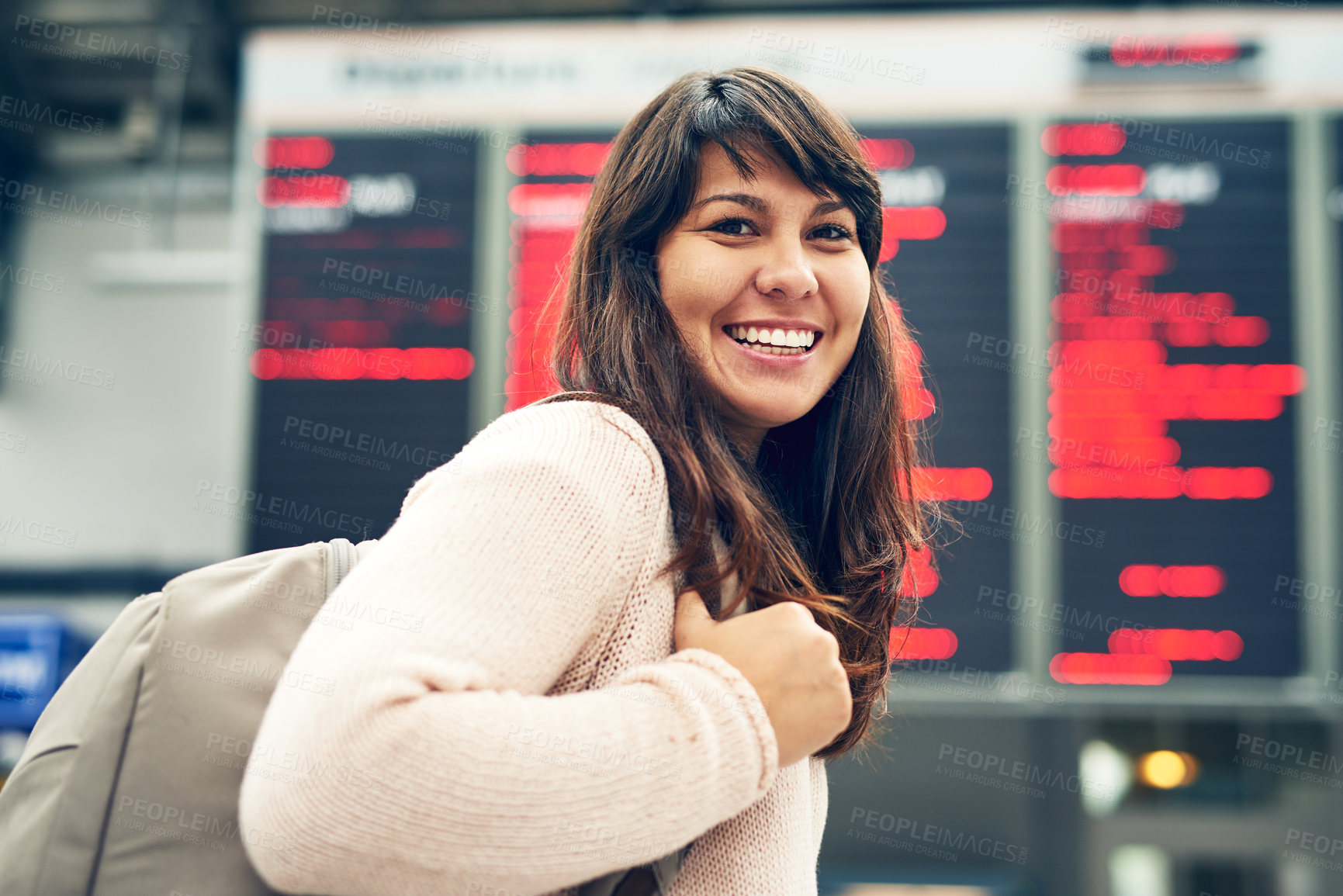 Buy stock photo Cropped portrait of an attractive young woman standing at an arrivals and departures board in the airport