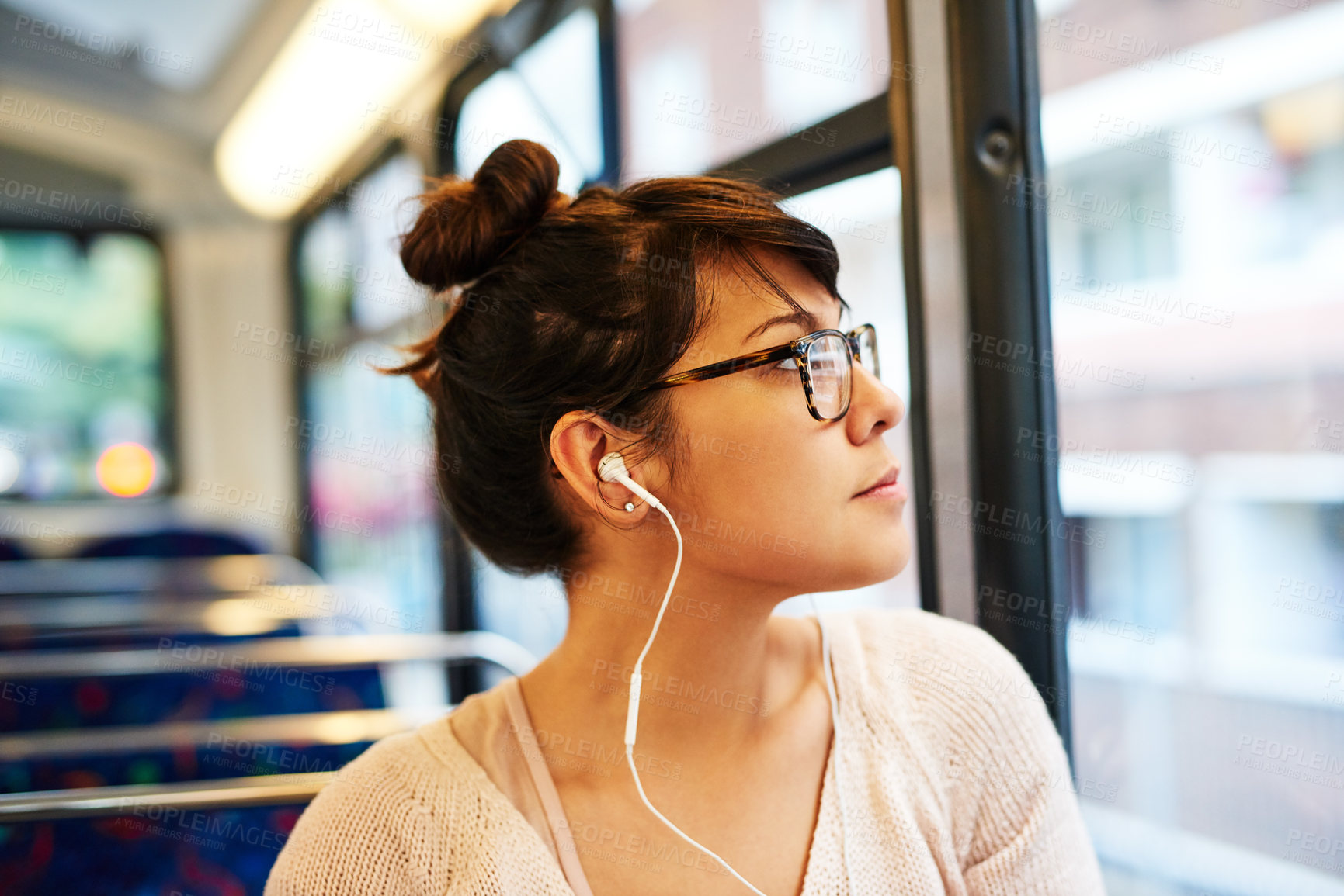 Buy stock photo Cropped shot of an attractive young woman listening to music while sitting on a bus