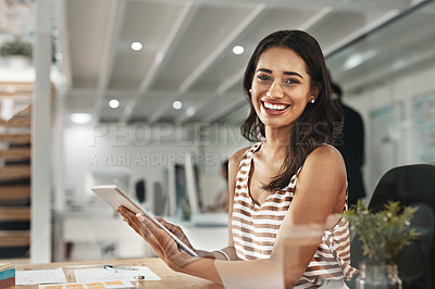 Buy stock photo Cropped portrait of an attractive young businesswoman working on her tablet in the office