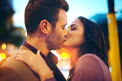 Buy stock photo Night, kiss and couple on date, street and bokeh of light, city and anniversary of man with partner. New York, outdoor and woman with love for marriage, relationship and happiness, together and dark