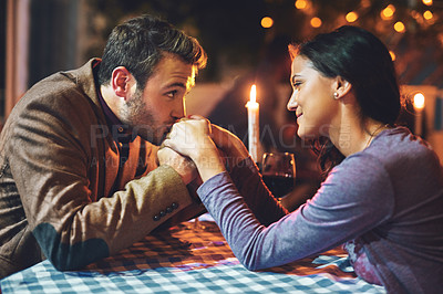 Buy stock photo Cropped shot of an affectionate young couple having a romantic dinner in a restaurant
