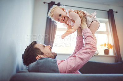 Buy stock photo Shot of a young man spending quality time with his adorable daughter at home