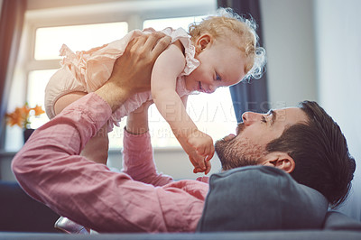 Buy stock photo Shot of a young man spending quality time with his adorable daughter at home