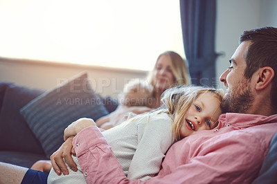 Buy stock photo Shot of an adorable young family of four relaxing together on the sofa at home