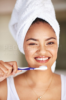 Buy stock photo Portrait of a young woman brushing her teeth in the bathroom