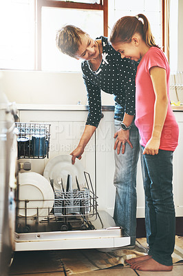 Buy stock photo Dishwasher, mother and daughter cleaning in kitchen together with help, learning or teaching. Housekeeping, mom and girl in happy home washing dishes in machine with smile, support and morning chores