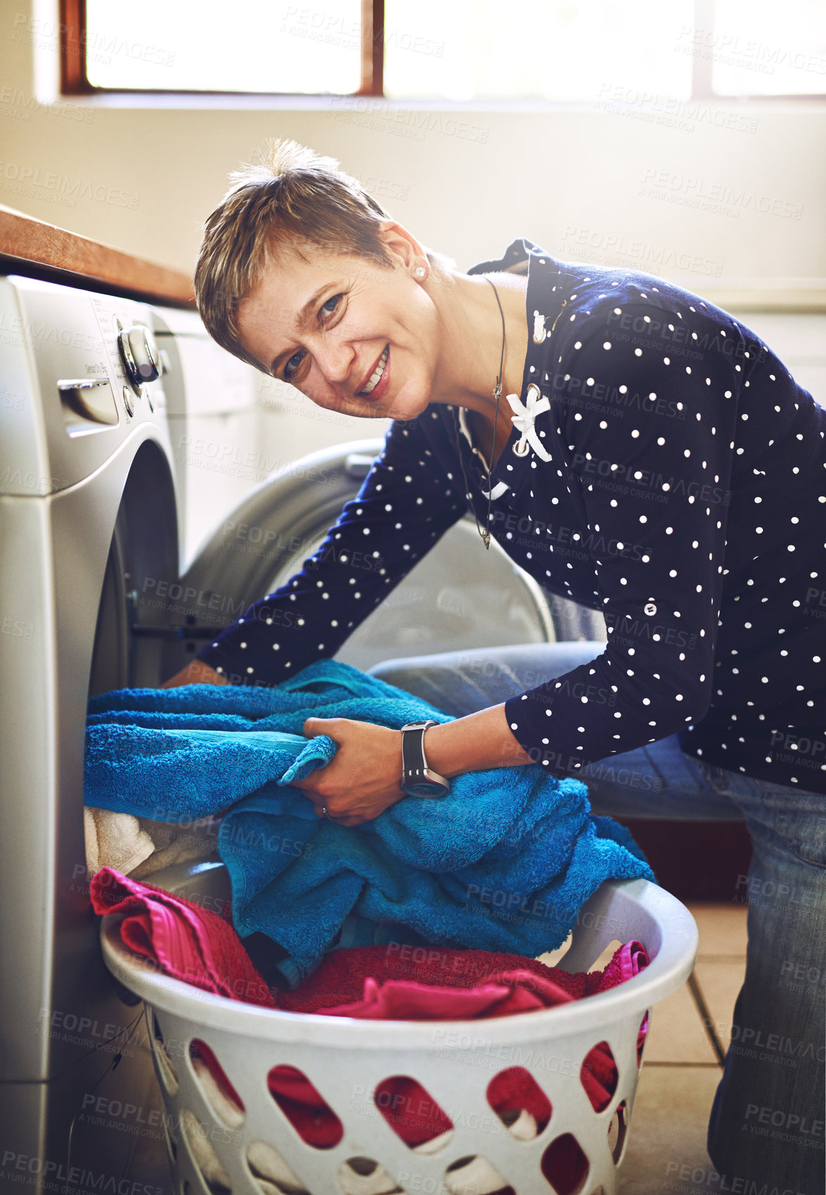 Buy stock photo Towel, washing machine and portrait of woman in home for clean fabric, housework and morning routine. Lens flare, laundry basket and female person for house linen, chores and housekeeping task