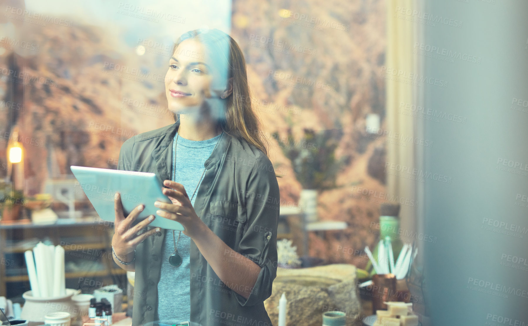 Buy stock photo Cropped shot of an attractive young female entrepreneur using a tablet in her store