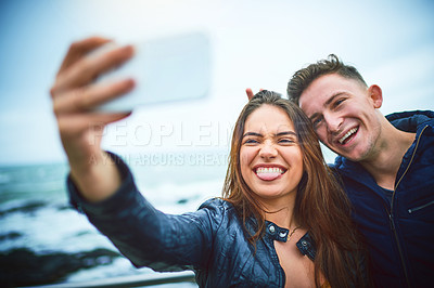 Buy stock photo Happy couple, beach and selfie with memory for photography, relationship or travel together in nature. Young, man and woman with smile for outdoor picture, moment or capture by ocean coast or sea