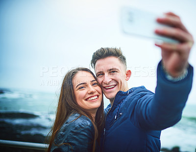 Buy stock photo Happy couple, beach and selfie with memory for picture, photography or relationship together in nature. Young, man and woman with smile for outdoor travel, moment or capture by ocean coast or sea