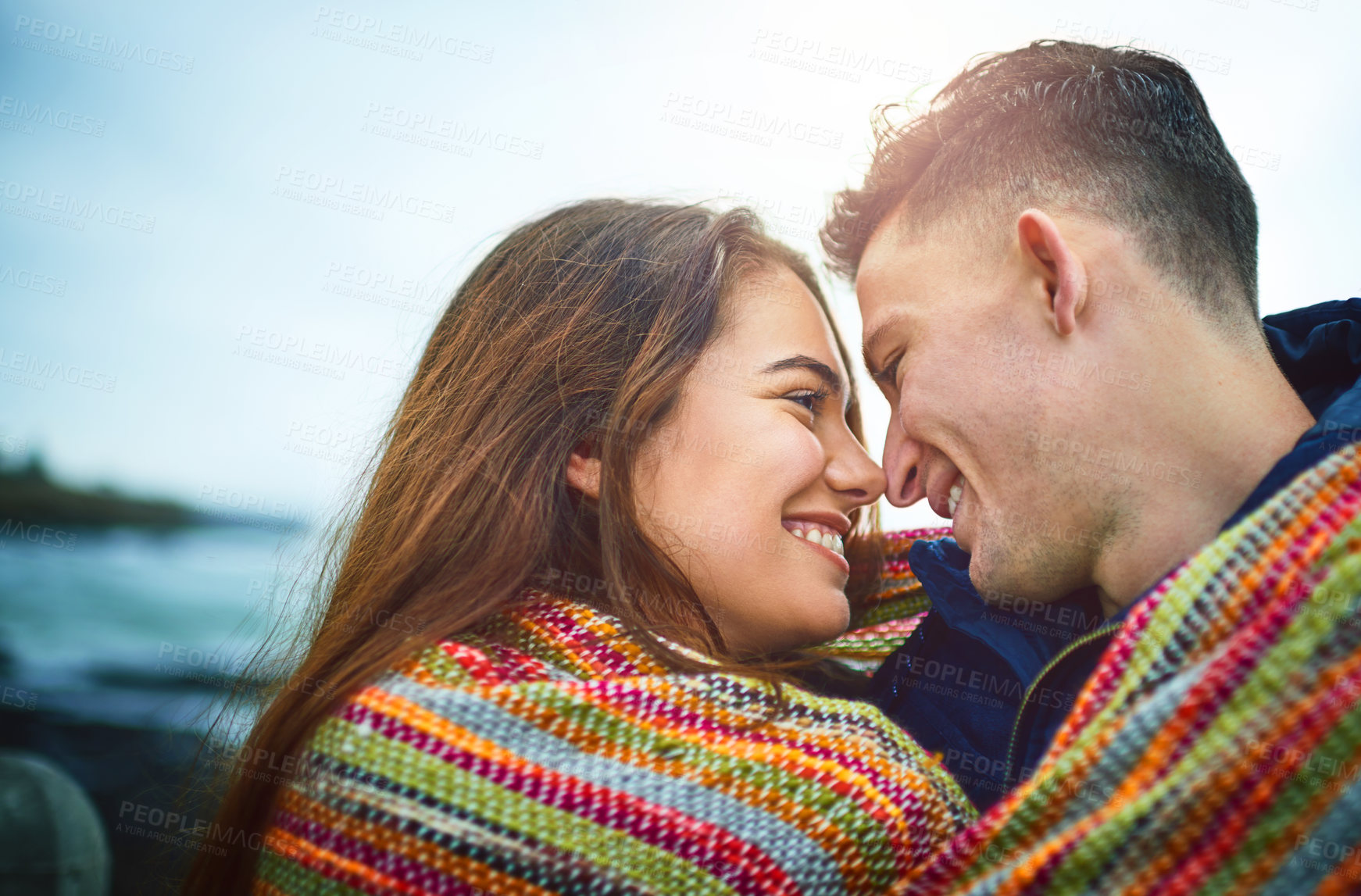 Buy stock photo Couple, happy and blanket by beach for love, bonding and relax with relationship, romance and date. Man, woman and smile outdoor for care, support and connection with partner, fun or weekend together