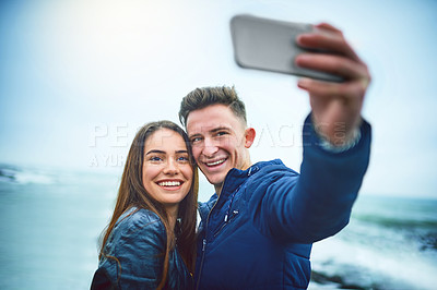 Buy stock photo Happy couple, beach and selfie with memory for travel, photography or relationship together in nature. Young, man and woman with smile for outdoor picture, moment or capture by ocean coast or sea