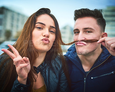 Buy stock photo Shot of a happy young couple sharing a playful moment outdoors