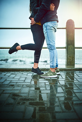 Buy stock photo Couple, legs and hug by beach for travel, bonding and relax with relationship, romance and date. Man, woman and love by ocean for care, support and connection with partner, break and weekend together