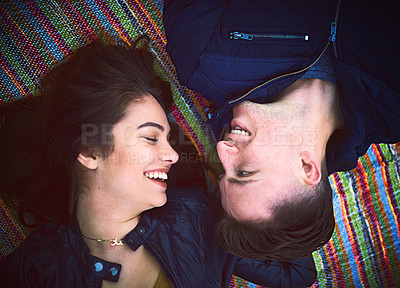 Buy stock photo Shot of a happy young couple lying on a blanket outdoors