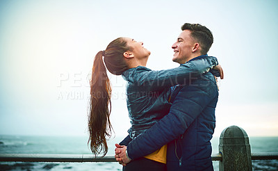 Buy stock photo Shot of a happy young couple embracing outdoors