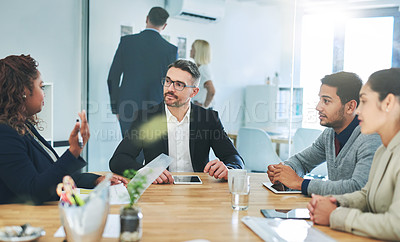 Buy stock photo Cropped shot of a group of corporate colleagues sitting in the boardroom during a meeting