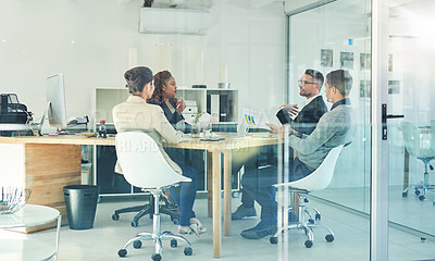 Buy stock photo Shot of a group of corporate colleagues sitting in the boardroom during a meeting