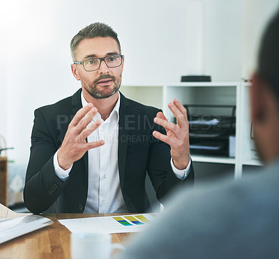 Buy stock photo Cropped shot of a group of corporate colleagues sitting in the boardroom during a meeting