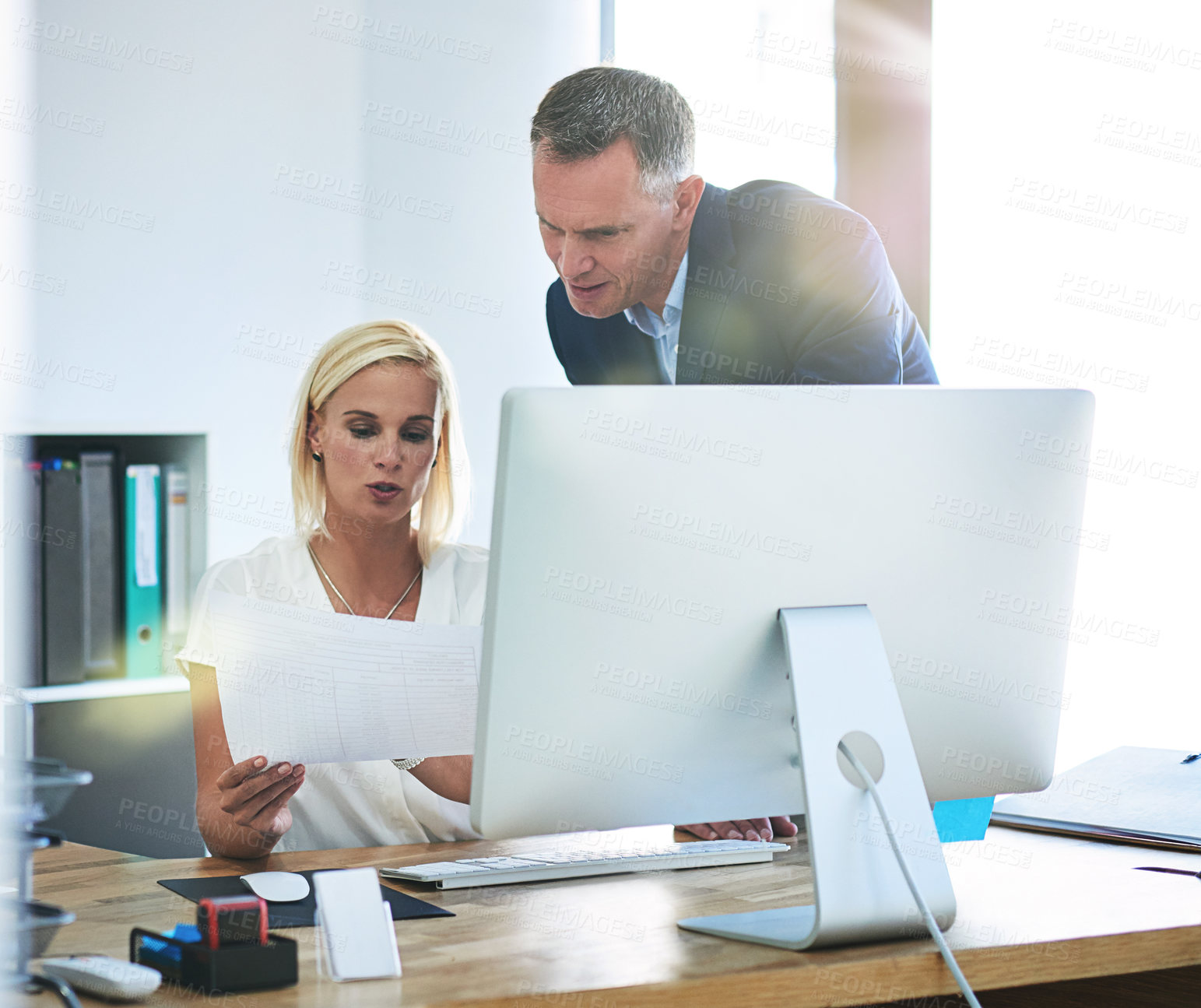 Buy stock photo Cropped shot of a mature businessman helping a younger female colleague in the office