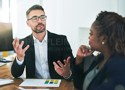 Buy stock photo Cropped shot of a group of corporate colleagues sitting in the boardroom during a meeting