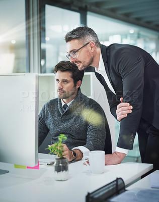 Buy stock photo Cropped shot of a mature businessman helping a younger male colleague in the office