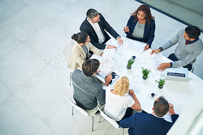 Buy stock photo High angle shot of a group of corporate colleagues sitting in the boardroom during a meeting