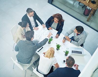 Buy stock photo High angle shot of a group of corporate colleagues sitting in the boardroom during a meeting