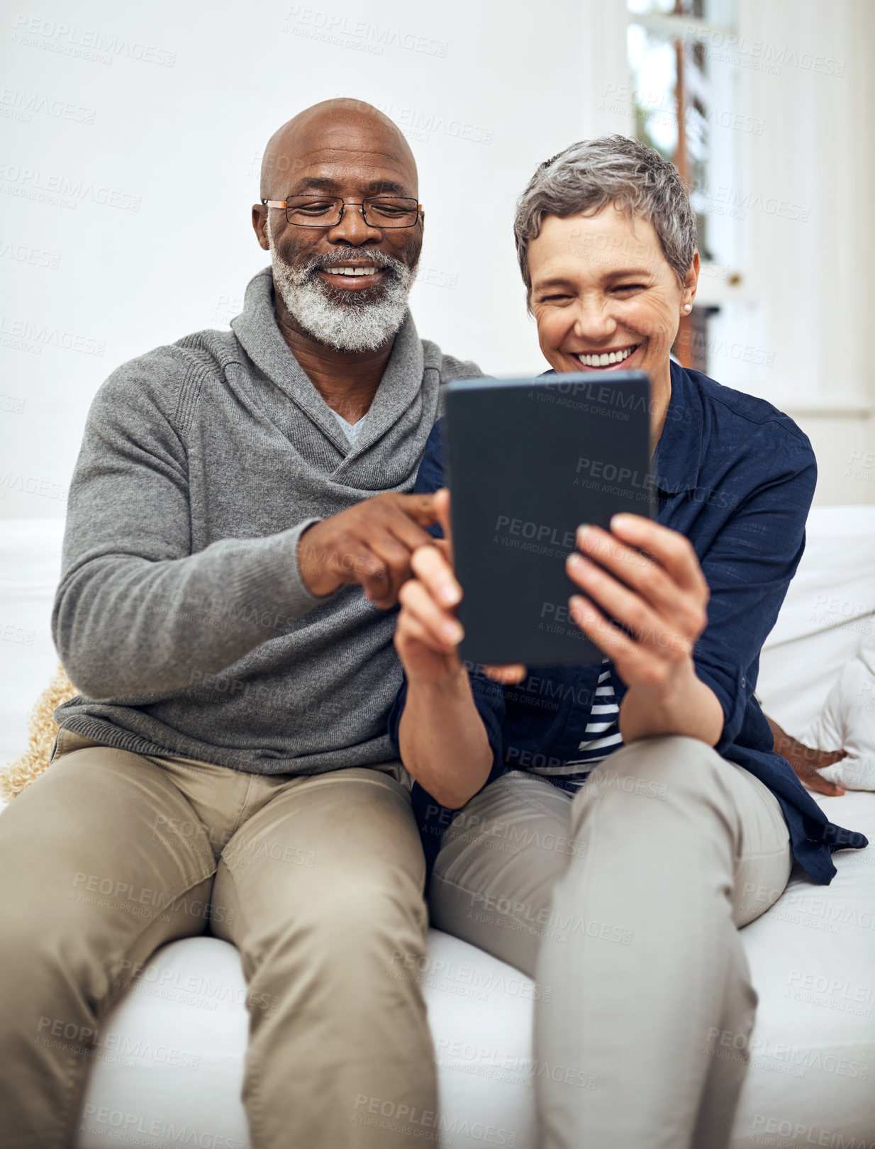 Buy stock photo Senior, couple and tablet on sofa together,  living room and browsing internet news or connection in apartment. Online, website and weekend or tech with interracial people, relationship and home