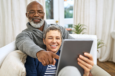 Buy stock photo Technology, senior couple with tablet and on sofa happy in living room of their home. Social media or streaming, retirement or relax and happy married people on couch laughing with digital device