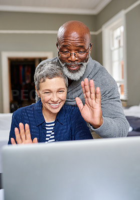 Buy stock photo Cropped shot of a senior couple waving while video chatting their laptop at home