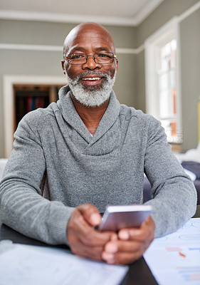 Buy stock photo Cropped portrait of a senior man using his cellphone while working on his finances at home