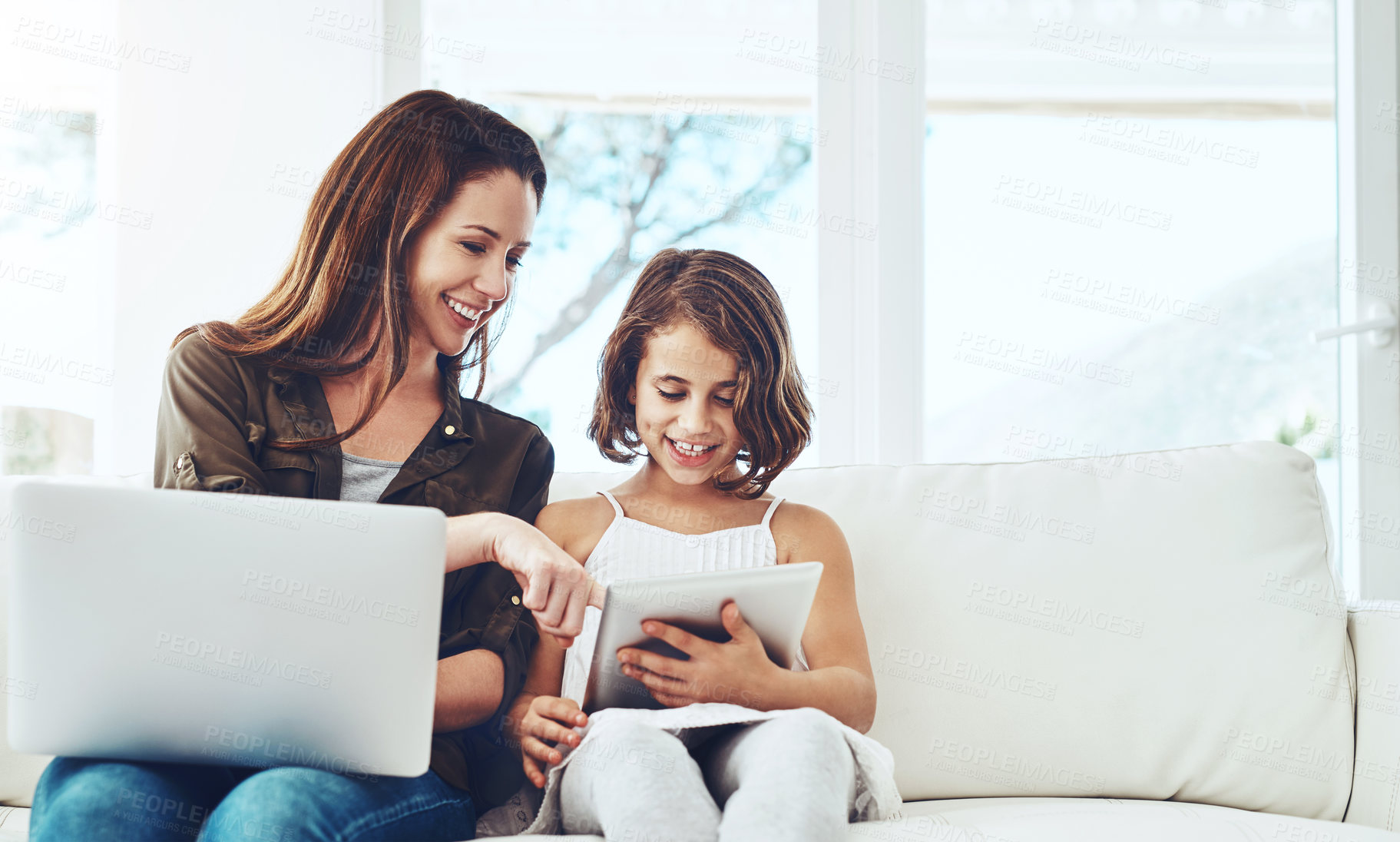 Buy stock photo Technology, mother on laptop and helping daughter on tablet sitting on sofa in the living room of their home. Social media or connectivity, networking or streaming and woman with child happy on couch