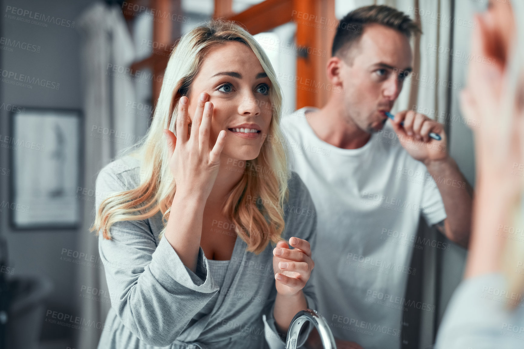 Buy stock photo Bathroom, couple and morning routine with woman on mirror to apply facial cream for skincare or beauty. Man, girl and brushing teeth with reflection in home for cleaning, hygiene or grooming together