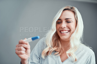 Buy stock photo Shot of a young woman looking at the results of her home pregnancy test