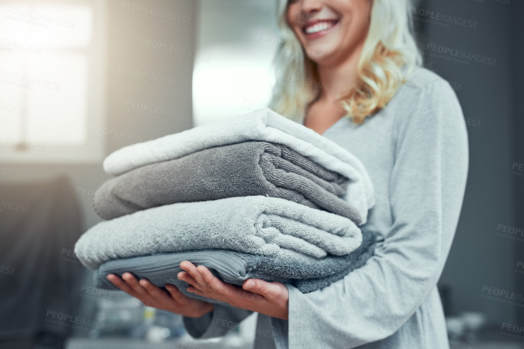 Buy stock photo Pile, towel and hands of person, smile and busy with spring cleaning, linen and routine for fresh stack. Home, washing and responsibility of housework, folded and task of laundry or texture of fabric