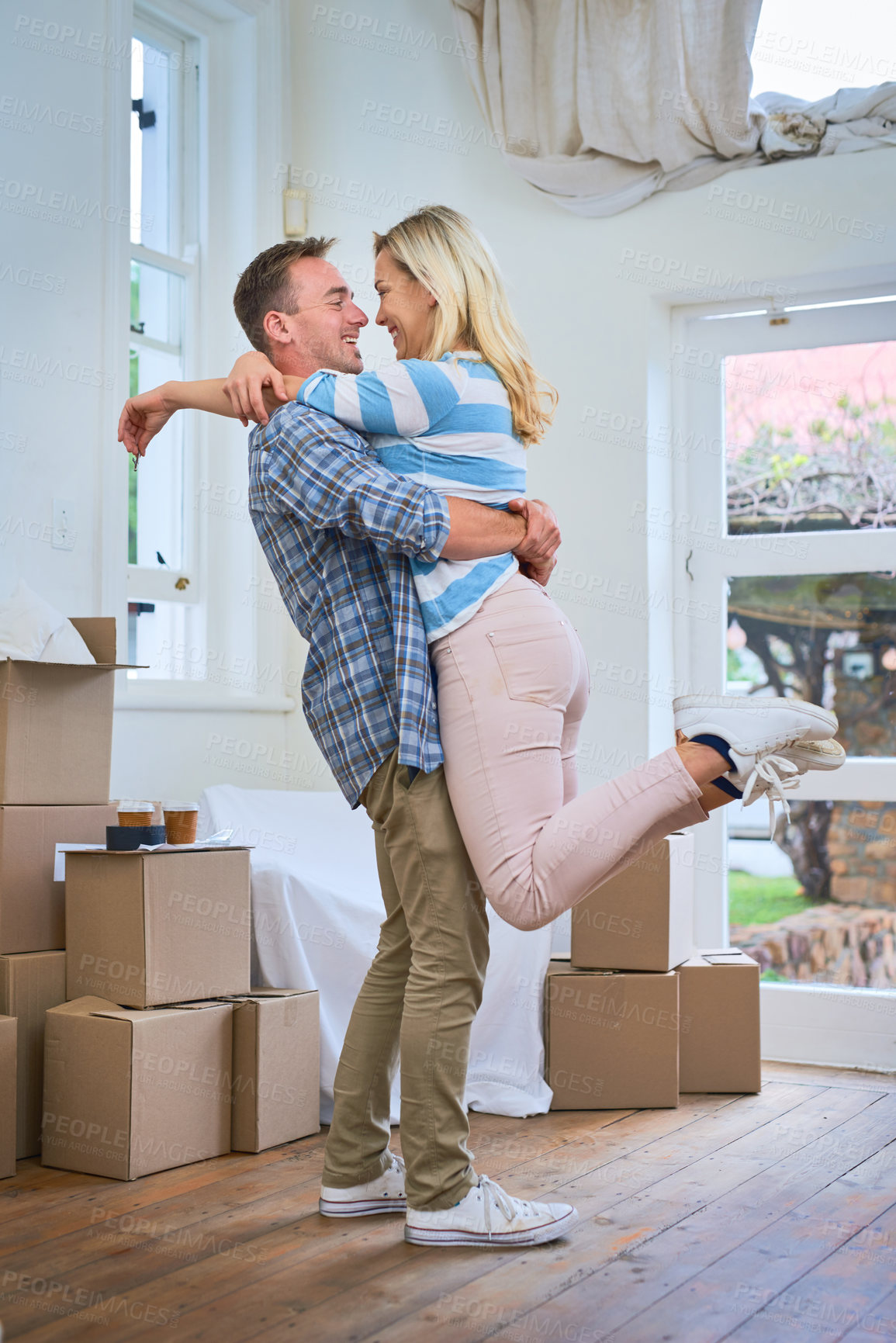 Buy stock photo Shot of a young couple celebrating their move into a new house