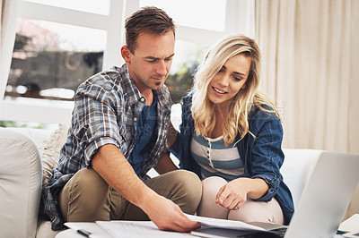 Buy stock photo Shot of a young couple doing their finances together at home