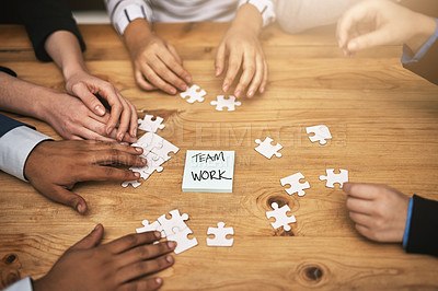 Buy stock photo High angle shot of a group of unrecognizable coworkers building a puzzle on their boardroom table