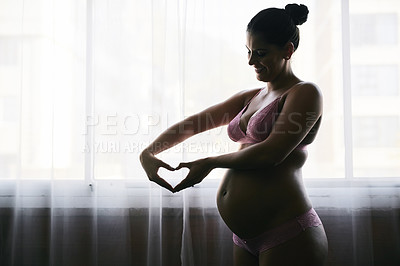 Buy stock photo Cropped shot of an attractive young pregnant woman standing in her bedroom at home