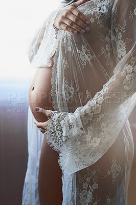 Buy stock photo Cropped shot of an unrecognizable pregnant woman standing in her bedroom at home