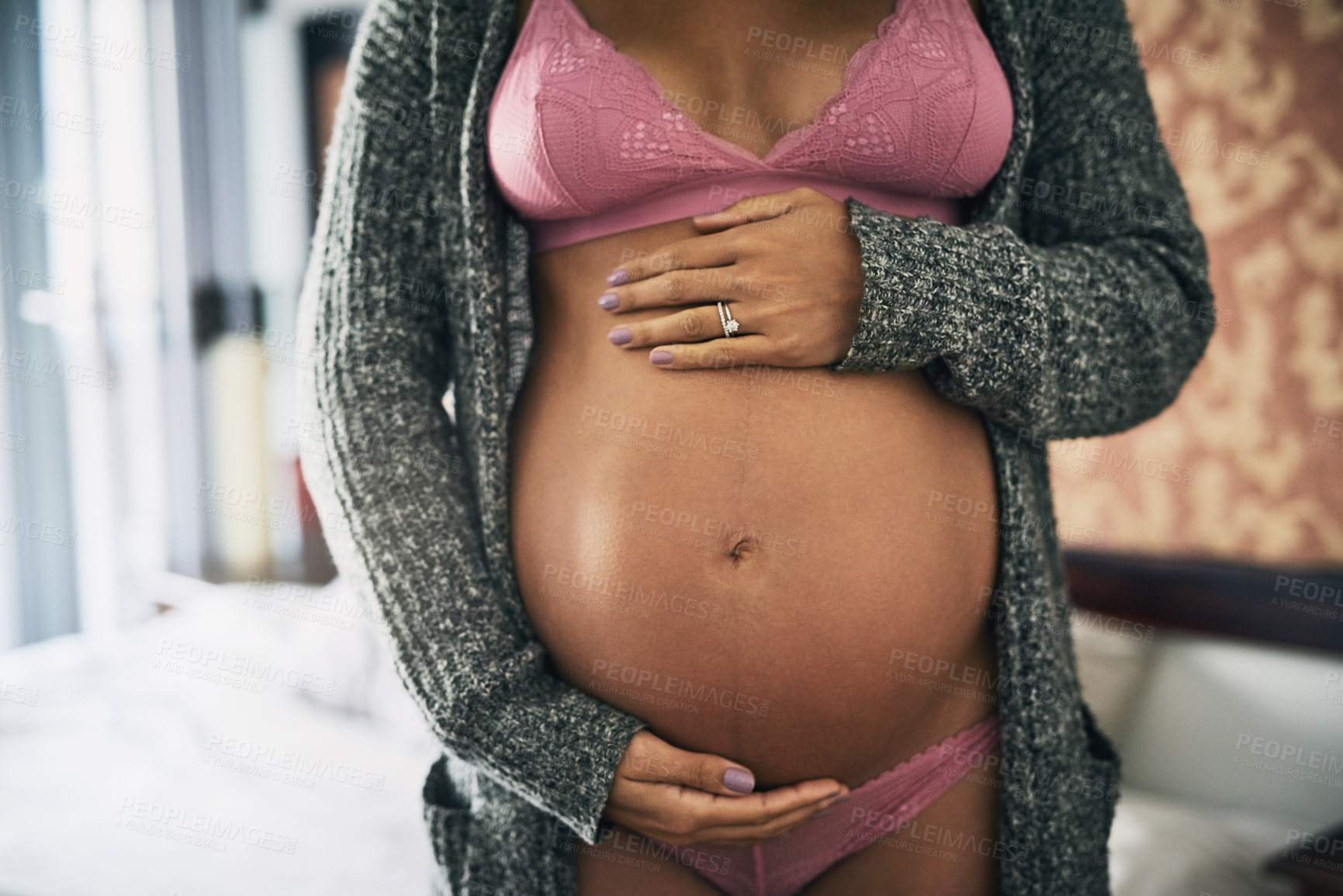 Buy stock photo Cropped shot of an unrecognizable pregnant woman standing in her bedroom at home